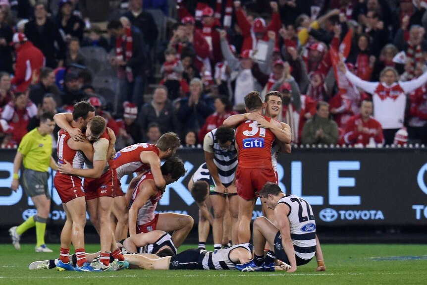 The Swans celebrate their win and the Cats react after their preliminary final in September 2016.