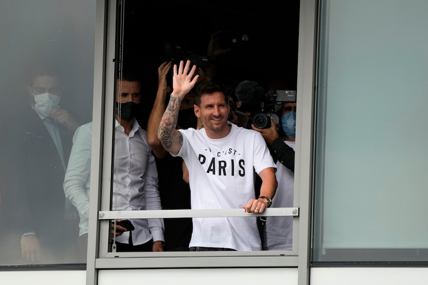 Lionel Messi waves to fans from Paris airport