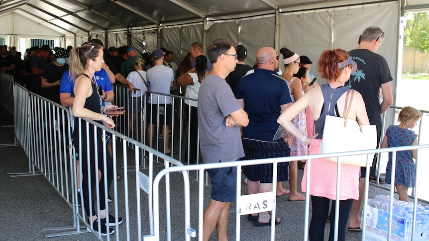 Long queues of people lining up in a tent