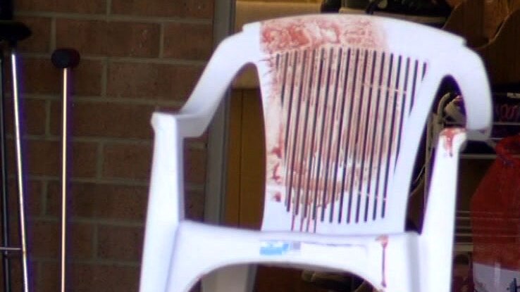 A blood stained plastic garden chair outside a house at Mill Park.