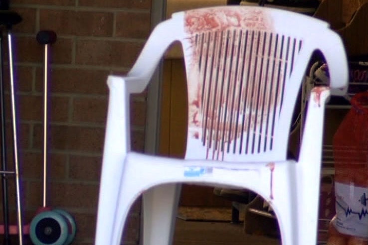 A blood stained plastic garden chair outside a house at Mill Park.