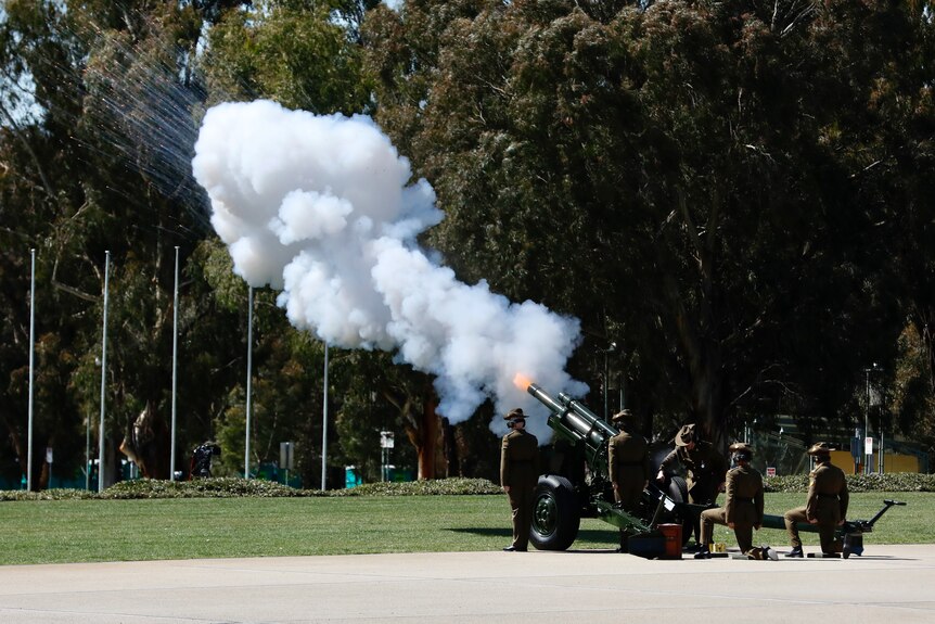 Smoke billows from an artillery gun on the lawns of Parliament House.
