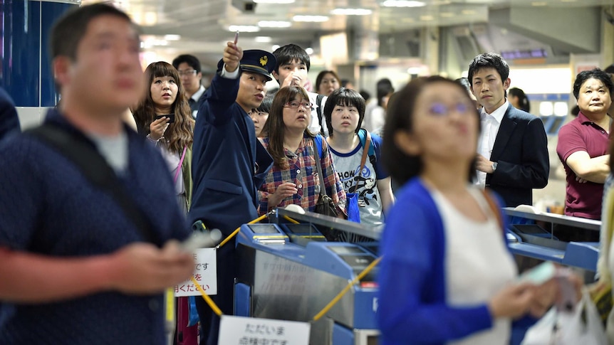 Passengers in Tokyo wait for bullet train operations to resume following the earthquake.