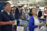 Passengers in Tokyo wait for bullet train operations to resume following the earthquake.