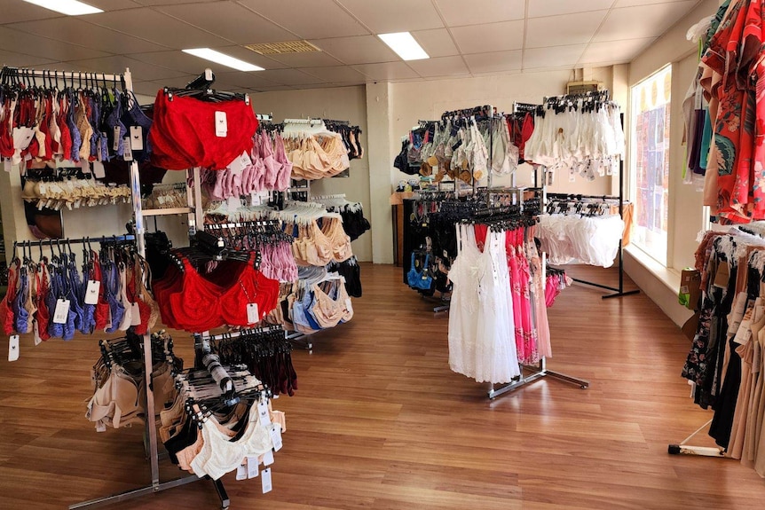 The inside of a shop with racks full of colourful bras. 