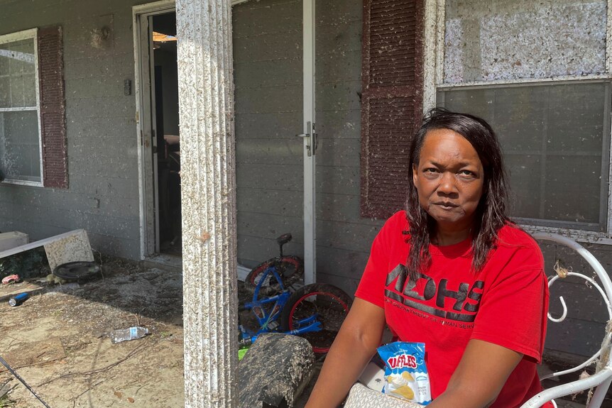 Christine Chinn in red shirt sits outside a home in Silver City Mississippi