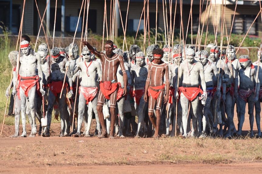 A group of men walk forward at a men's ceremony in Wadeye.