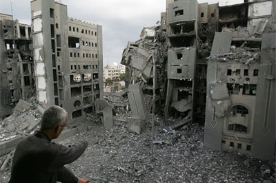 Man surveys bombsite from the balcony of his home in Gaza