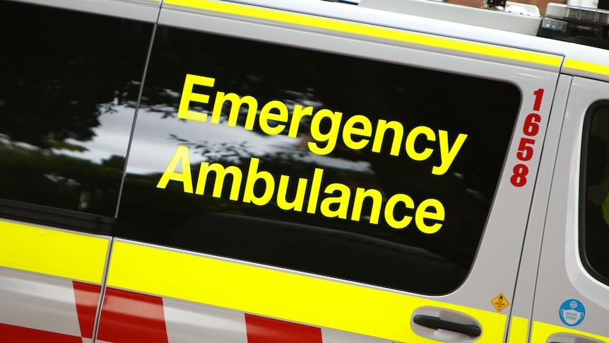 A close up of the words "Emergency Ambulance" on the side of an ambulance.