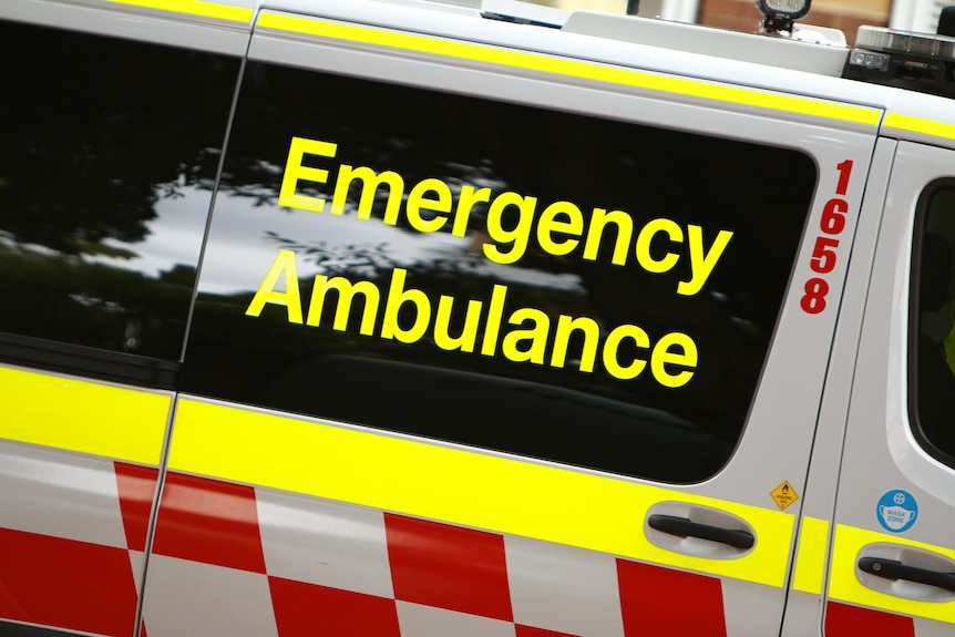 A close up of the words "Emergency Ambulance" on the side of an ambulance.