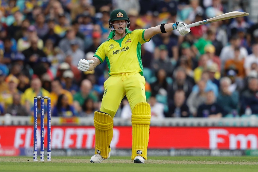 Steve Smith points his bat in the air and shouts with his eyes closed