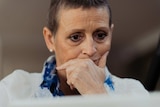 Cancer patient Jane Downs looks at her laptop with a worried look on her face.