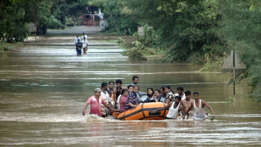 Villagers ride raft through floodwaters