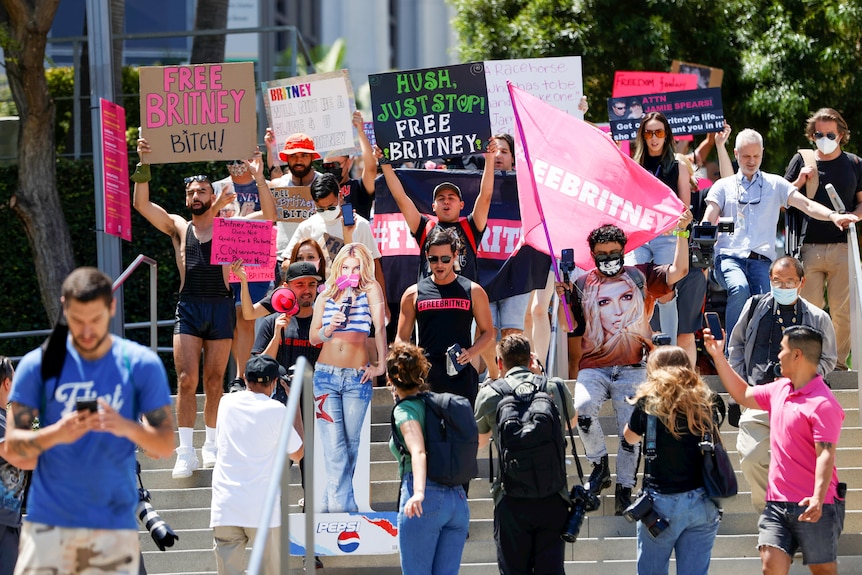 A group of protesters on court steps holding 'Free Britney' signs 