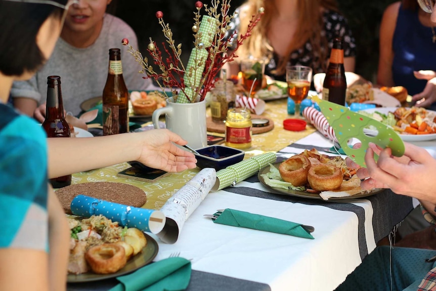 La gente si riunisce intorno al tavolo per il pranzo di Natale