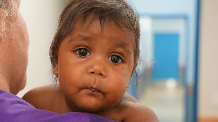 A baby looks into the camera in Lajamanu.