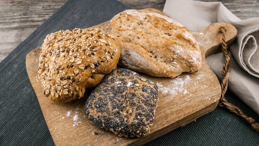 Three loaves of bread on a board.