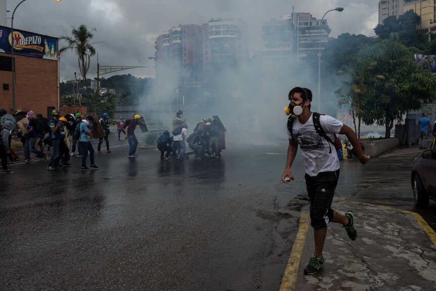 Men run as tear gas fills the air