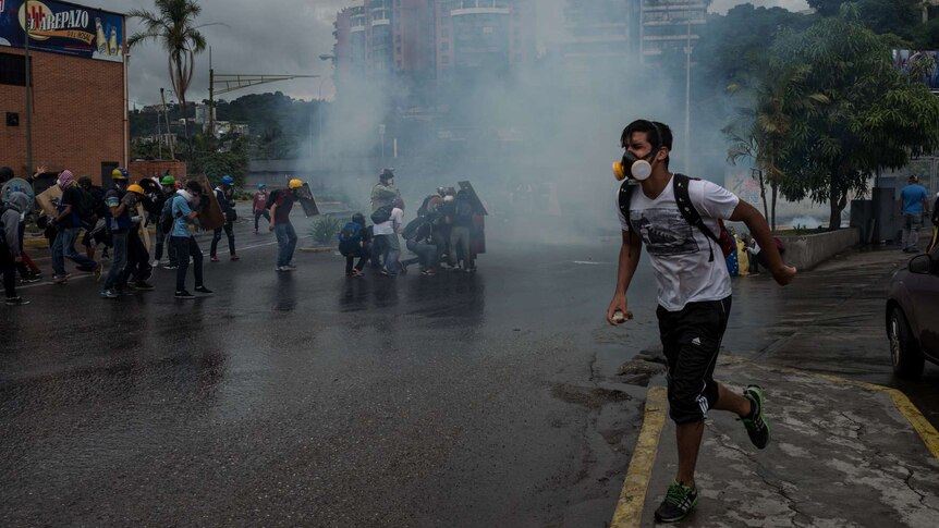 Men run as tear gas fills the air
