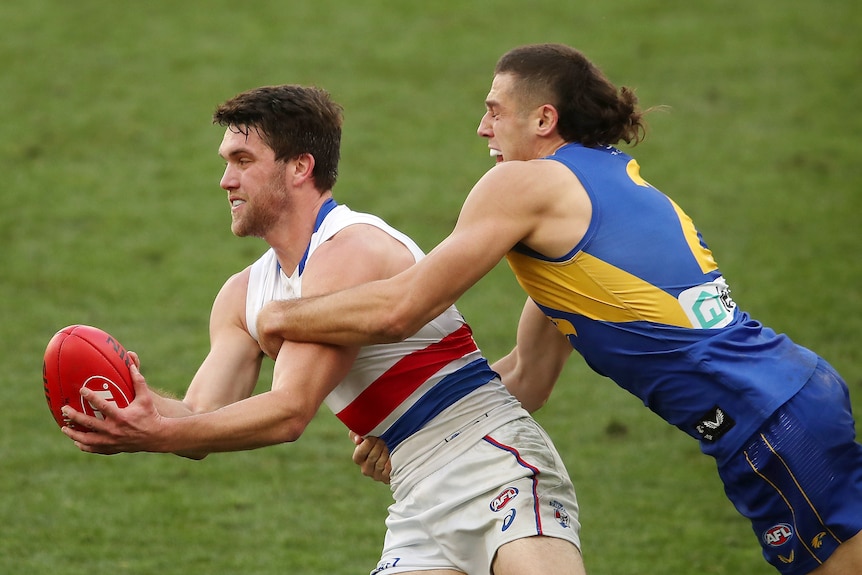 One AFL player tackles another.