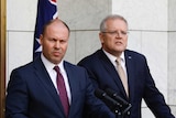 Josh Frydenberg and Scott Morrison stand in a court yard at podia with an australian flag behind them