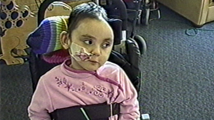 Teagan Ferguson strapped to a chair with a tube attached to her face.