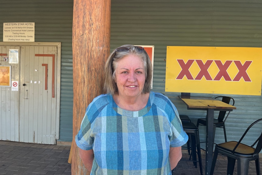 Older woman wearing blue with a 4X sign in the back