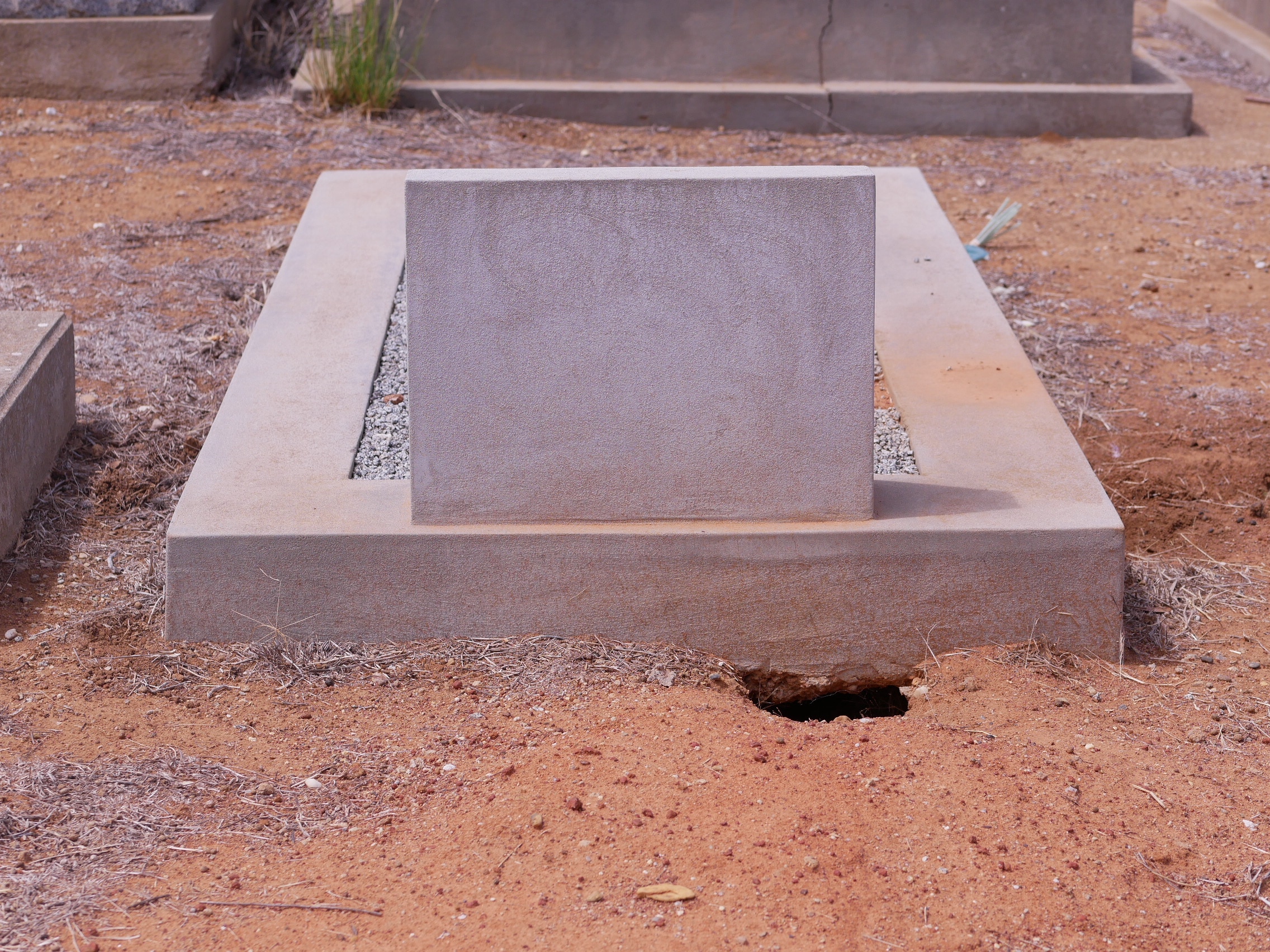 Una imagen de una tumba con una madriguera de conejo en la esquina. 