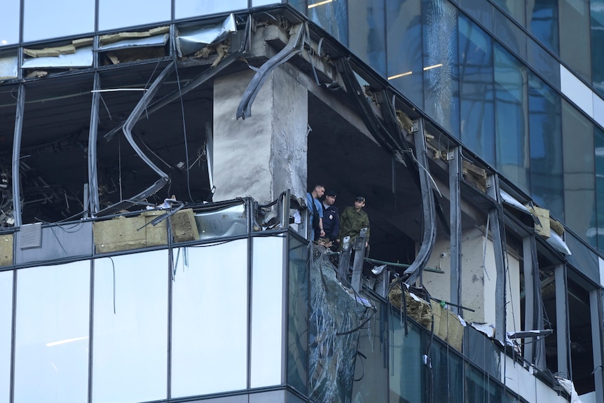 Investigators examine a damaged skyscraper after a reported drone attack in Moscow, Russia.