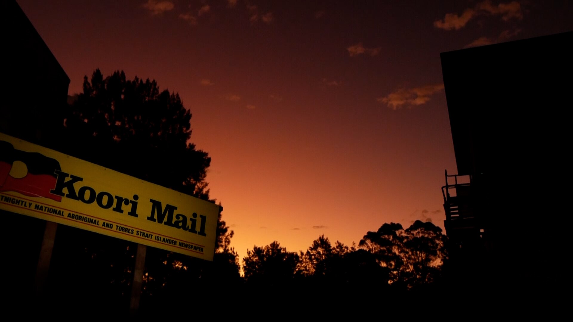 A sign saying 'Koori Mail' at sunset