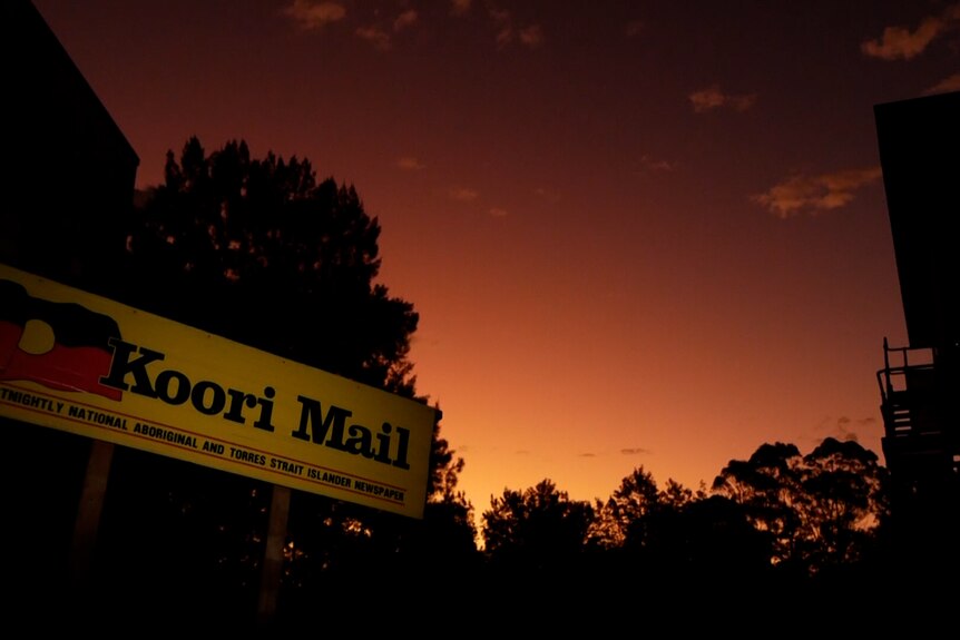 A sign saying 'Koori Mail' at sunset