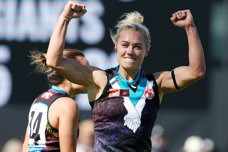Erin Phillips raises her arms to celebrate a goal for the Power against the Giants.