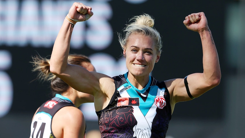 Erin Phillips raises her arms to celebrate a goal for the Power against the Giants.