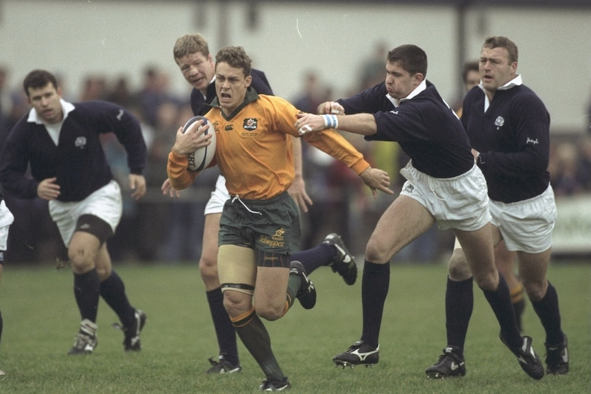 A man runs the ball during a rugby match