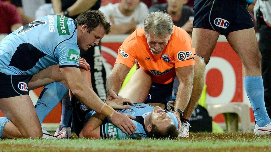 NSW player Brett Morris is comforted by his brother Josh (left) while in pain after scoring a try.