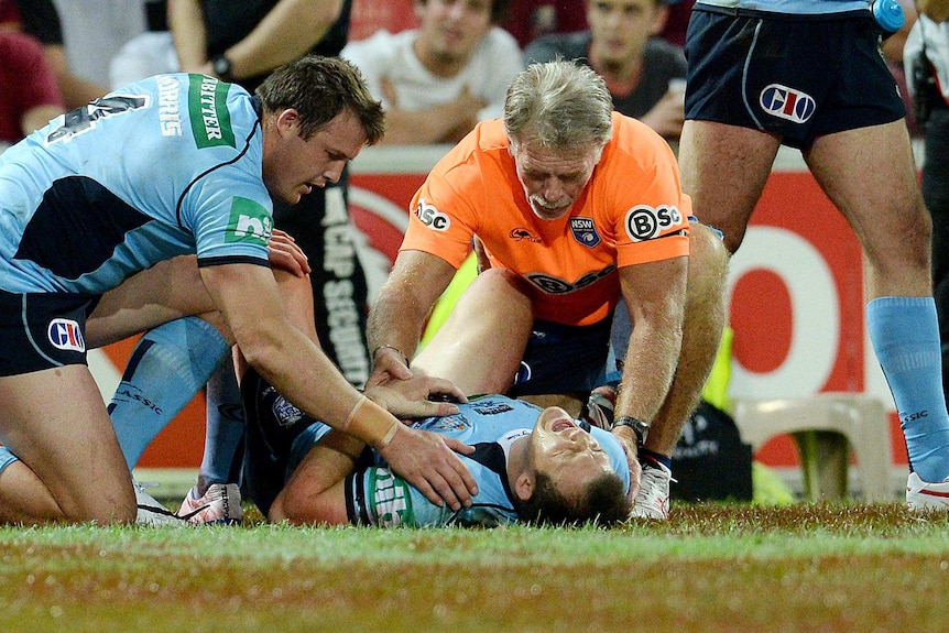 NSW player Brett Morris is comforted by his brother Josh (left) while in pain after scoring a try.