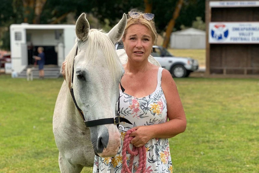 A woman stands with her horse on the oval at Balhannah.