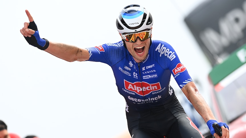 An Australian cyclist shouts with joy and points his finger in triumph as he crosses the line to win a stage at the Vuelta.