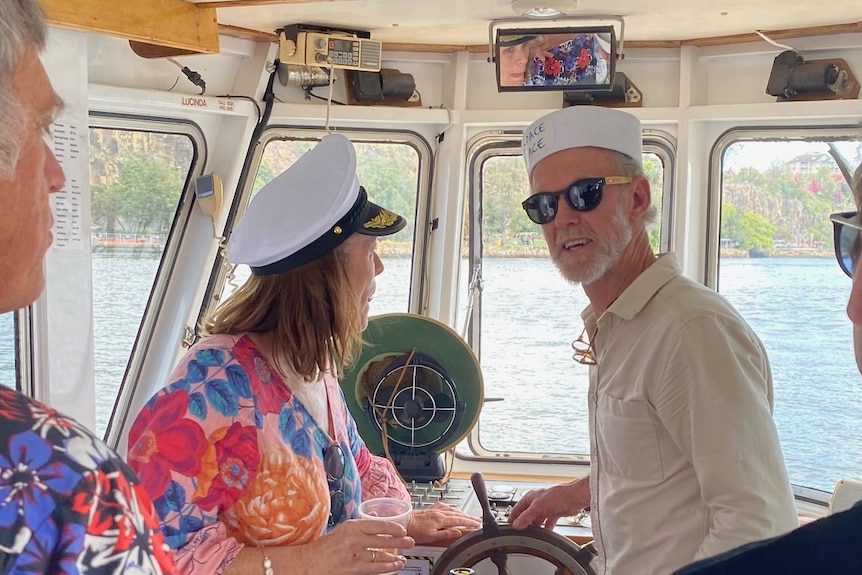 Man in naval cap at helm of ferry