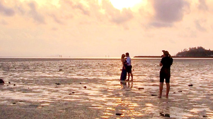 A couple are photographed on a beach on Hayman Island.