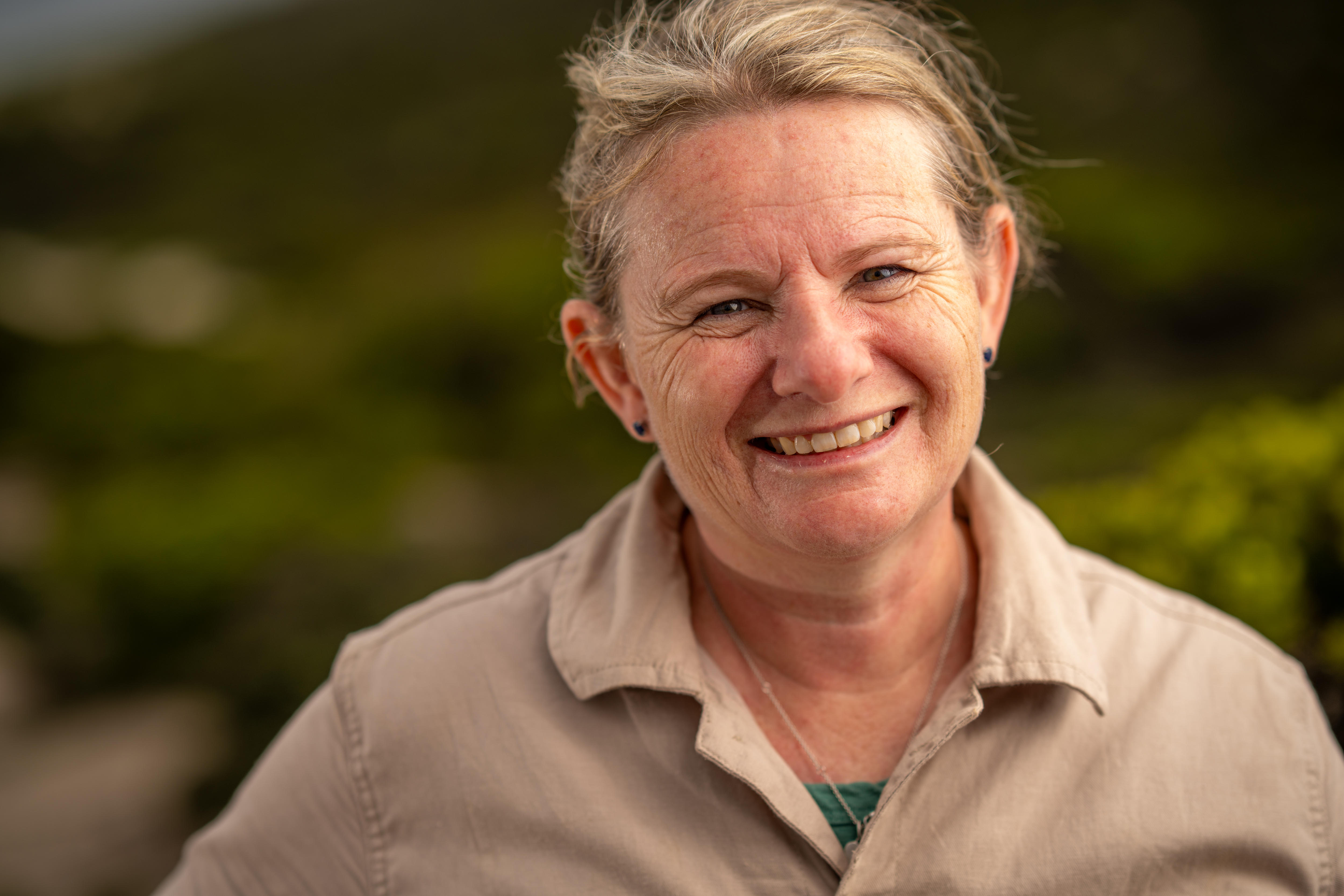 Uma mulher sorri para a câmera.