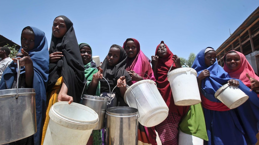 Women in Somalia hold buckets.