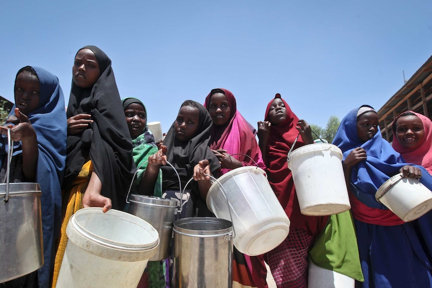 Women in Somalia hold buckets.