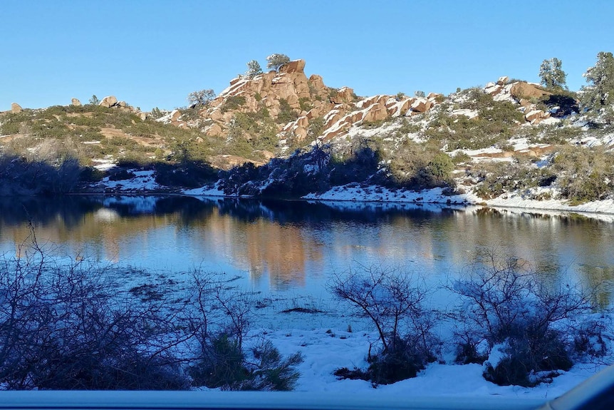 A waterway in Oak Flat with the surrounding rocks shrouded in snow.