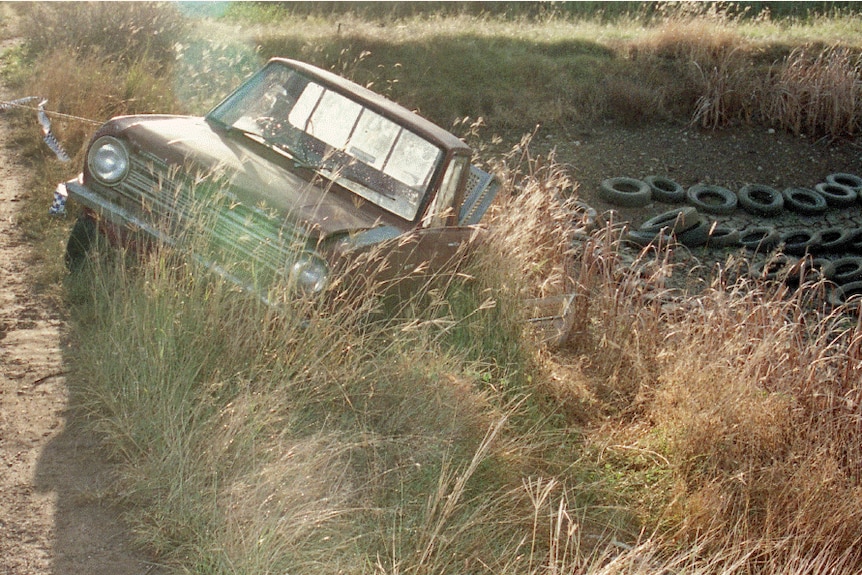 A ute slanting off a dirt road.