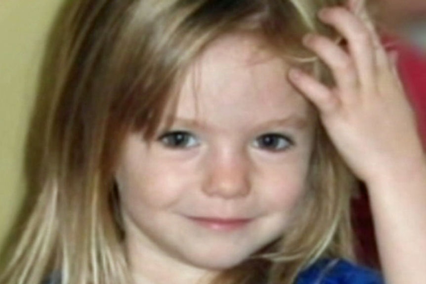 A young girl pushes her hair back from her forehead