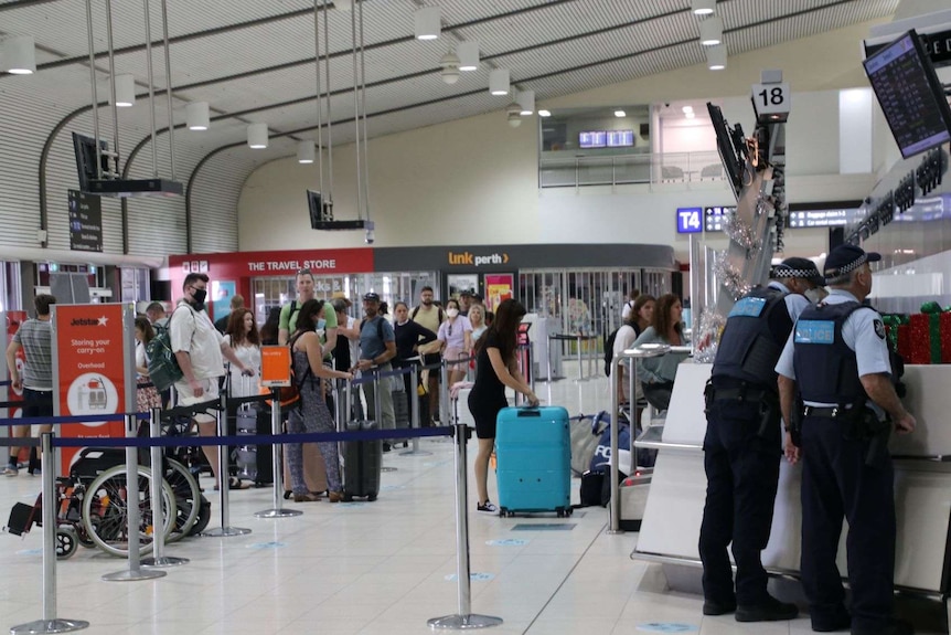 Passengers at Perth Airport line up to check in.