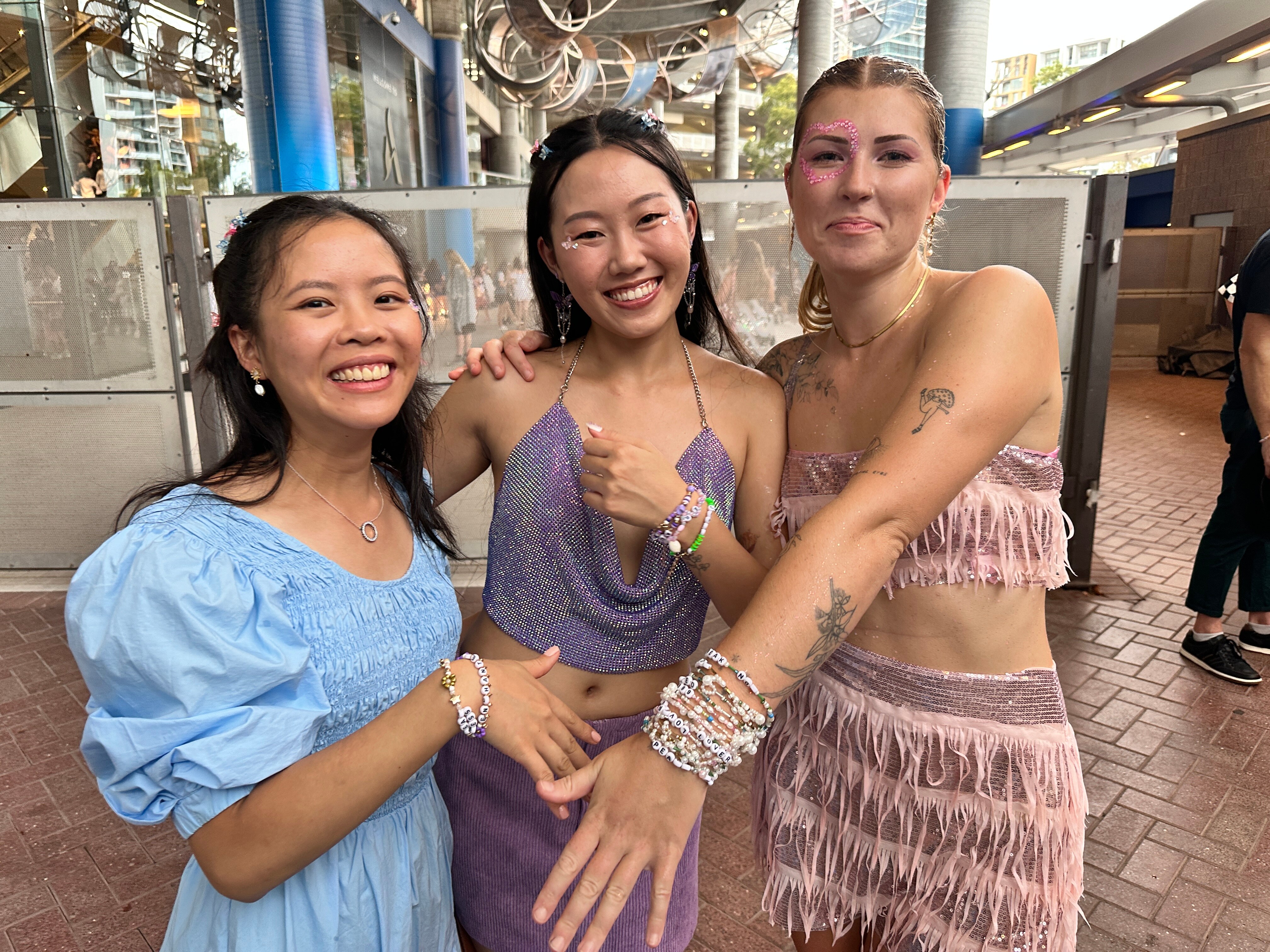 taylor swift fans outside sydney accor stadium wearing bracelets 