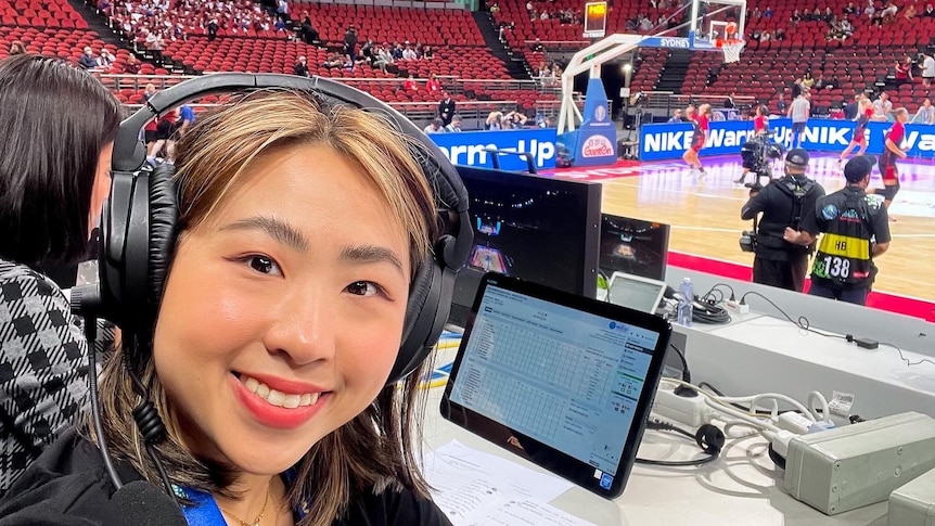 A woman with a headset on at a basketball court