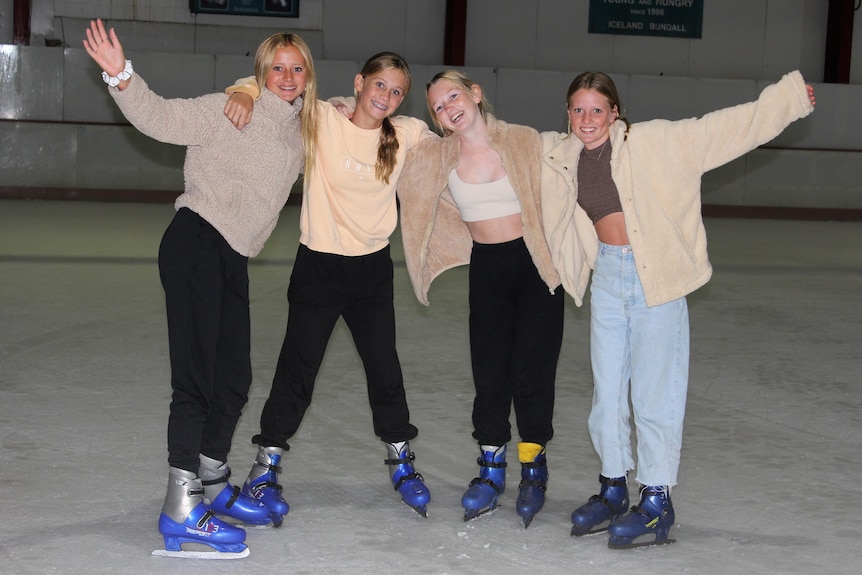 four teenage girls at an ice rink